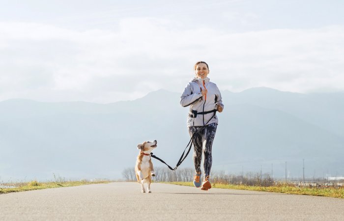 woman running with dog on leash